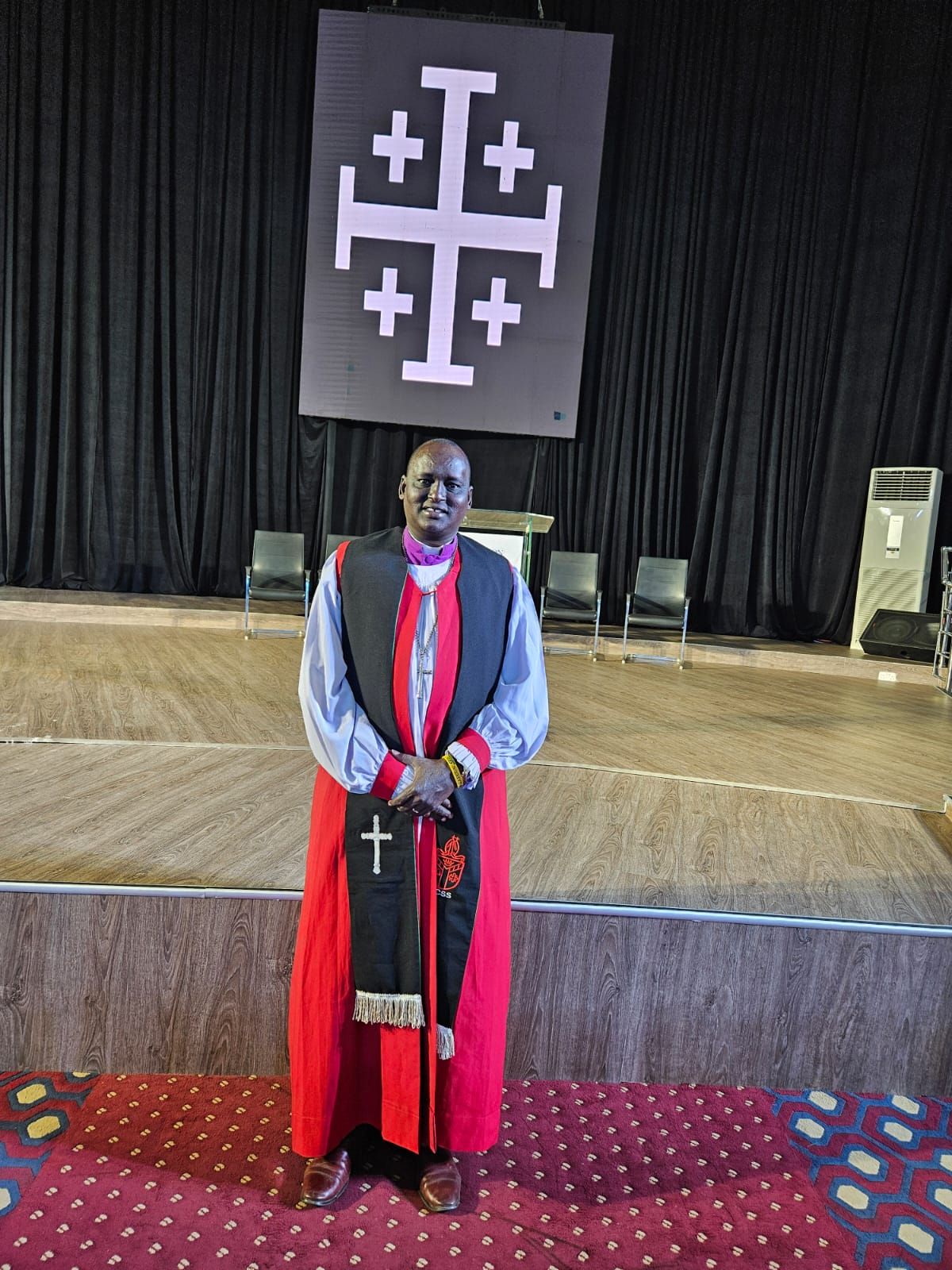 Bishop in convocation robes before the Jerusalem cross